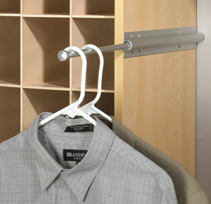 A gray checked shirt on a white hanger, hanging on a metal rod against a wooden cubbyhole background.