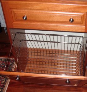 An open drawer with a wire basket insert.