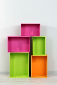Colorful stacked storage boxes against a white wall.