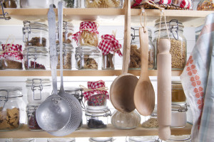 Kitchen shelf with hanging utensils and jars of ingredients.