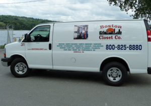 Commercial van for Boston Closet Co. parked by a waterside, displaying company branding and contact information.