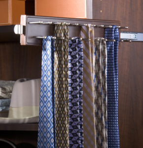 A collection of neckties hanging neatly on a tie rack inside a wooden closet.