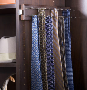 A selection of neckties arranged on a tie rack inside a wooden wardrobe.