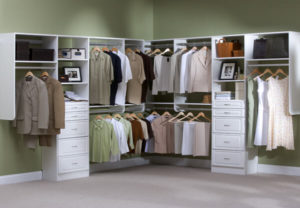 A well-organized walk-in closet with a variety of clothes and storage drawers.