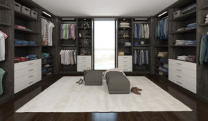 Modern walk-in closet with organized storage, seating, and a bright window.