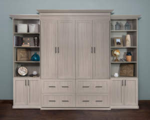 An elegant, cream-colored wooden entertainment center with shelving, cabinets, and drawers.