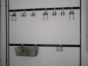 Wall-mounted hooks and a wire basket on a white background.
