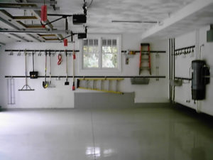 Empty garage with various tools hanging on the wall.