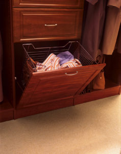 Open wardrobe drawer with clothes and a shoe rack inside.