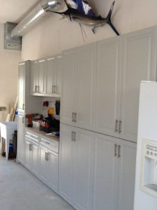 A garage interior with white cabinets and a mounted fish decoration above.