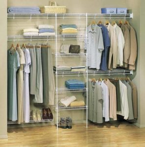 An organized walk-in closet with neatly arranged clothes and shoes.
