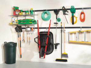Organized garage wall with tools and equipment neatly hung and shelved.