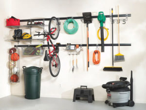 Organized garage storage system with tools, bicycle, and cleaning equipment neatly mounted on the wall.