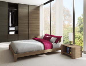 Modern bedroom interior with a wooden bed, white and red bedding, floor-to-ceiling windows, and an open wardrobe.