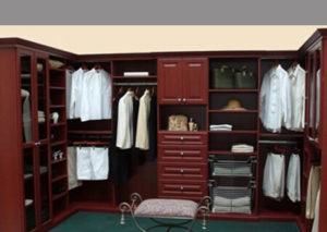 Elegant walk-in closet with mahogany shelves and white clothing.
