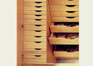 Wooden shoe cabinet with open drawers revealing stored shoes.