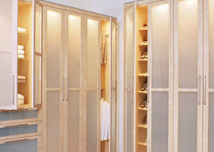 A clean and organized linen closet with open doors and shelves neatly stacked with towels and linens.