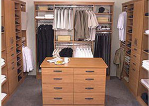 Walk-in closet with organized clothing and a central island dresser.