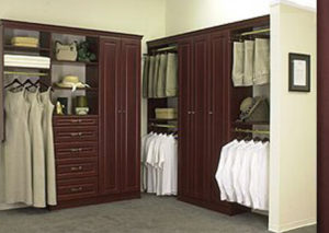 A well-organized walk-in closet with wooden cabinetry and a variety of clothes and accessories on display.