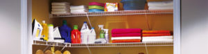 Organized laundry room with detergents, cleaning supplies, and neatly stacked linens.