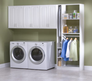 A laundry room with a white washer and dryer set, wall-mounted cabinets, and an open storage shelving unit with cleaning supplies and hanging clothes.