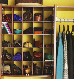 Organized closet with shelves of shoes and hanging clothes.
