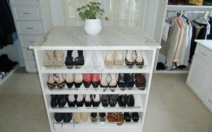 White shoe rack with various pairs of shoes organized in a closet.