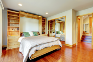 Bright and spacious bedroom with wooden furnishings and hardwood floors.