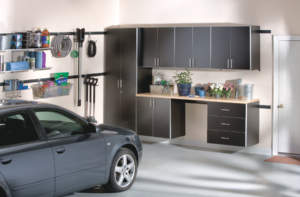Organized garage with storage cabinets and a car parked inside.