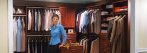 A woman standing inside a well-organized walk-in closet.