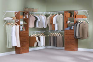 Organized walk-in closet with clothes arranged on hangers and shelves.