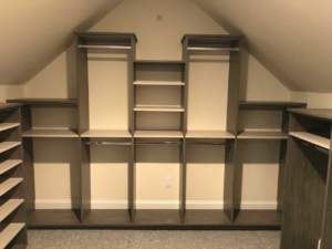 Custom built-in shelves and cabinets designed to fit under a sloping ceiling.