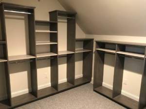 Built-in wooden shelving units in a carpeted room.