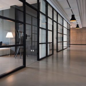 Modern office space featuring glass walls, minimalist design, and a custom closet.