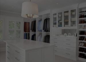 An organized walk-in closet with built-in cabinets and a central island.