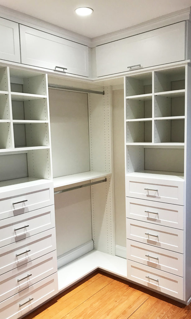 Empty built-in closet with shelves and drawers in a modern home interior.