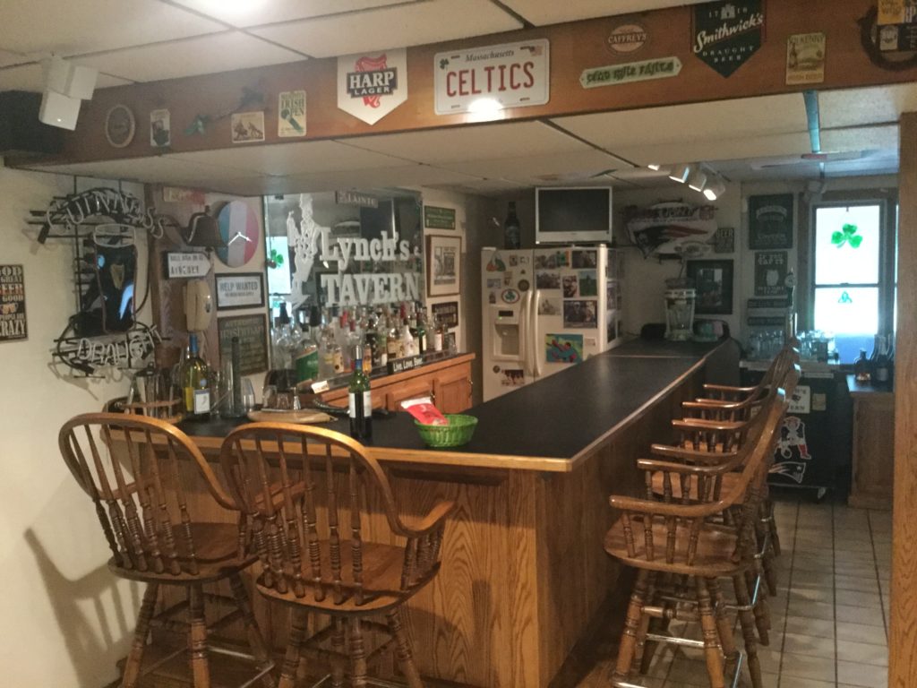 A custom man cave setup decorated with sports memorabilia and branded signage.