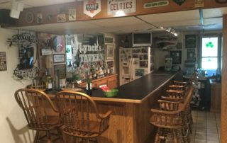 A custom man cave setup decorated with sports memorabilia and branded signage.