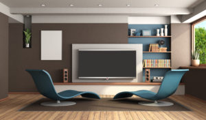Modern living room with stylish blue chairs and an entertainment system including a wall-mounted television.