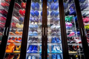Wall display of colorful sneakers arranged in rows on shoe organization shelves.