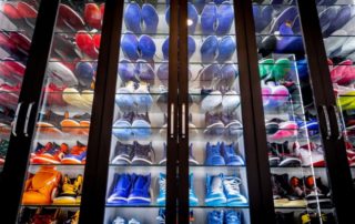 Wall display of colorful sneakers arranged in rows on shoe organization shelves.