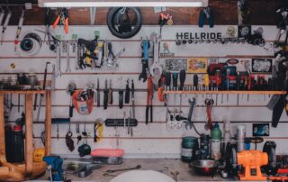 A highly organized workshop with tools neatly hung on the wall and shelves storing equipment.