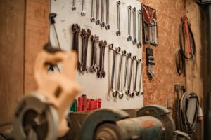 A display of wrenches organized neatly on a wall above a workbench in a workshop.