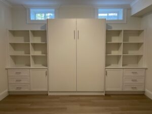 White built-in wardrobe, Murphy Bed, and shelving units in a well-lit room.