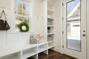 Bright mudroom with built-in bench and storage, looking out towards a driveway.