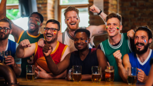 A group of men cheering and enjoying a sports game in their man cave.