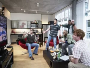 Group of men enjoying a sports game on television in a Man Cave setting.