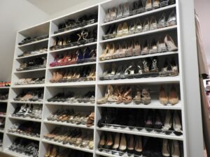A neatly organized shoe storage closet with multiple shelves displaying a variety of women's footwear.