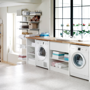 A bright laundry room with a washer, dryer, and neatly organized shelves in the laundry rooms.