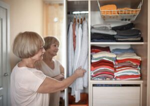Senior woman organizing clothes in a reach-in closet.